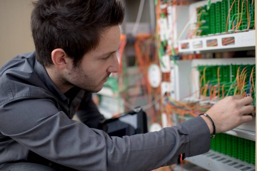 Un employé Orange mettant en place de la fibre optique. 